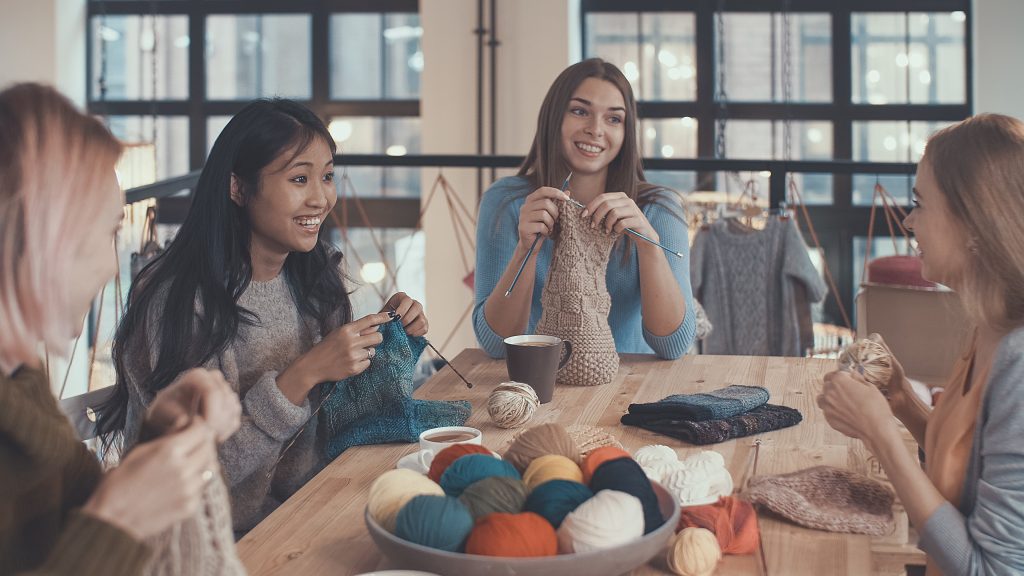 Vier junge Frauen stricken zusammen