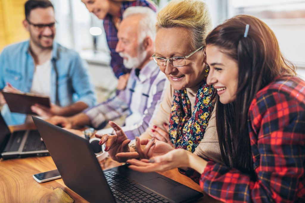 Junge Frau erklärt älterer dame den Computer