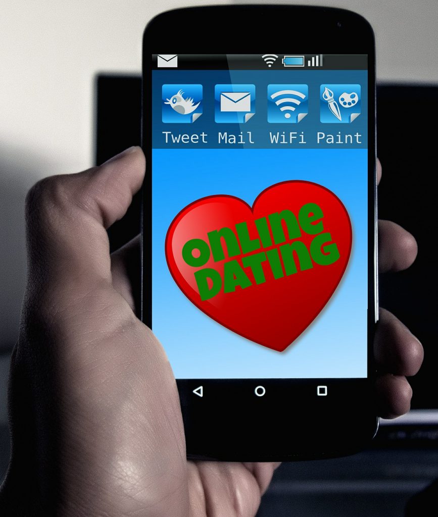 Hand hält Smartphone mit Dating-App zur Partnersuche 50plus