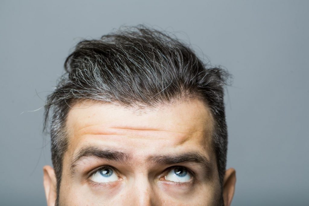 Obere Gesichtshälfte eines Mannes mittleren Alters mit leicht grauen Haaren.