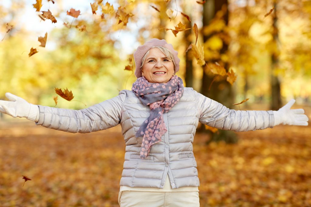 Fröhliche ältere Damen genießt den sonnigen Herbst