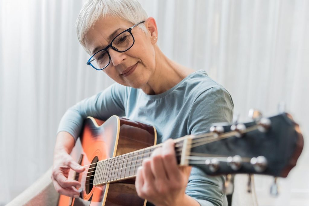 Reife Frau spielt Gitarre